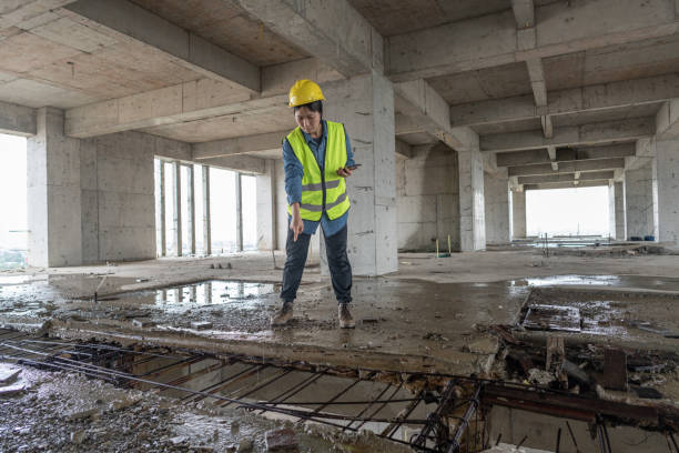An Asian female engineer was checking the water leakage at the building site
